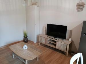 a living room with a television and a table at Le manège Gite Etretat in Sainte-Marie-au-Bosc