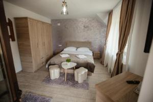 a small bedroom with a bed and a table at Pensiunea Alexandra 