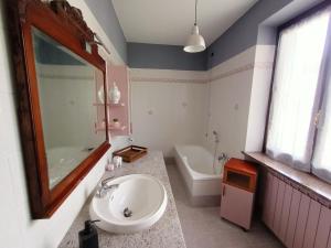 ein Badezimmer mit Waschbecken, Spiegel und Badewanne in der Unterkunft Ca 'd Baloc in San Marzano Oliveto