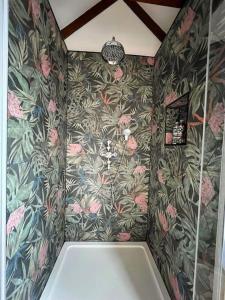 a bathroom with a shower with a floral wallpaper at The Snuggery 