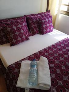 a bottle of water is sitting on a bed at Résidence des amazones Appartement 1 in Cotonou