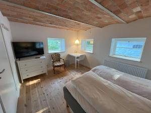 a bedroom with a bed and a television and a table at Solbjerg Skov B&B in Solbjerg