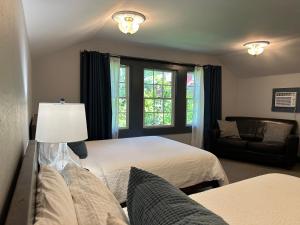 a bedroom with two beds and a couch and a window at Westfir Lodge in Oakridge