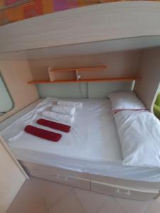 a small bed with two pillows on top of it at Ema's Apartment in Durrës +6 photos