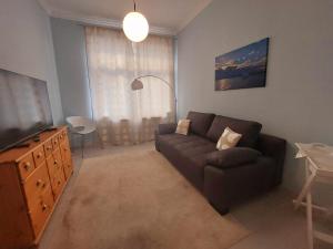 a living room with a couch and a television at Gemütliche Zwei-Zimmer-Ferienwohnung "W1" in Zwenkau bei Leipzig im Neuseenland in Zwenkau