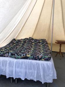 a bed in a tent with a blanket on it at Glampingtält in Torsby