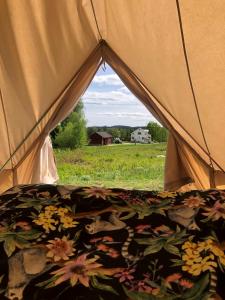 - une tente avec un oreiller floral dans un champ dans l'établissement Glampingtält, à Torsby