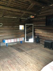 pokój z ławką i drzwiami w drewnianym domku w obiekcie Glampingtält w mieście Torsby