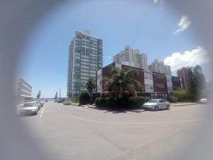 una calle con coches estacionados en un estacionamiento con edificios altos en Hotel Gaudí, en Punta del Este