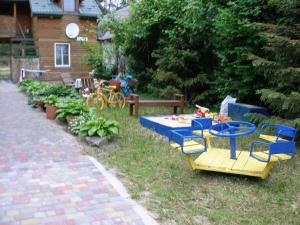einen Hinterhof mit einem Tisch und Stühlen sowie einem Tisch und Stühlen in der Unterkunft Світязький хуторок in Switjas