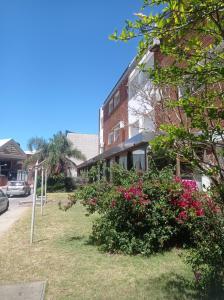 ein Gebäude mit rosa Blumen vor einem Gebäude in der Unterkunft Hotel Gaudí in Punta del Este