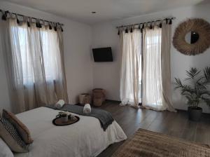 a bedroom with a large bed and two large windows at Villa Paradou in Paradou