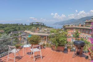 d'une terrasse avec des chaises et un barbecue sur un balcon. dans l'établissement Attico con Terrazza e Piscina, à Camogli