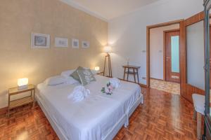 - une chambre avec un lit blanc orné de fleurs dans l'établissement Attico con Terrazza e Piscina, à Camogli