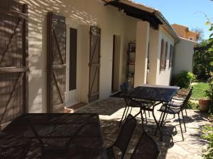 um pátio com uma mesa e cadeiras em frente a uma casa em maison de vacances avec piscine à Saint Remy de Provence em Saint-Rémy-de-Provence