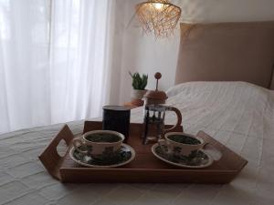 zwei Tassen Kaffee auf einem Tablett auf einem Bett in der Unterkunft Baltic Nature in Łukęcin