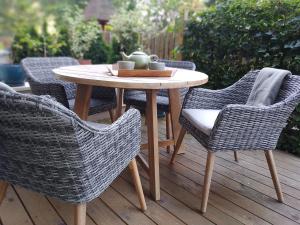 a wooden table and chairs on a deck with a table and chairs at Baltic Nature in Łukęcin