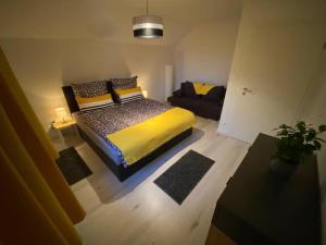 ein Schlafzimmer mit einem Bett und einem Sofa darin in der Unterkunft Ferienwohnung Eifel Stadtkyll in Stadtkyll