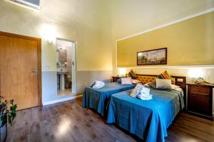 um quarto de hotel com duas camas com lençóis azuis em Hotel Minerva em Pisa