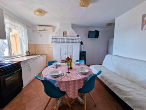 a kitchen with a table and chairs in a room at Vila Cicovac in Novalja