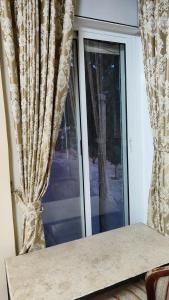 ein Fenster mit Vorhängen und einem Tisch davor in der Unterkunft George apartments in Bethlehem