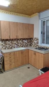 eine leere Küche mit Holzschränken und einem Fenster in der Unterkunft George apartments in Bethlehem