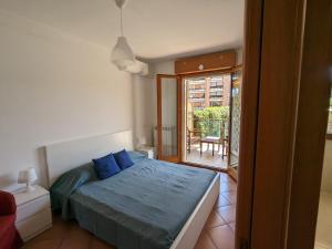 a bedroom with a bed with blue pillows and a balcony at Residenza Alabama in Rome