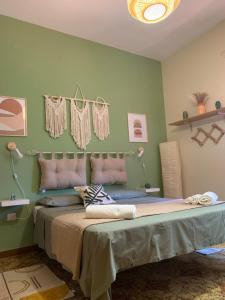 ein Schlafzimmer mit einem Bett mit einer grünen Wand in der Unterkunft Casa Vacanze La Brii in Iglesias