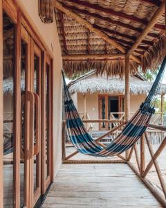 uma rede de descanso num alpendre de um resort em Pousada Vila Tapera em Barra Grande