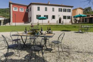 a table with chairs and bottles of wine in front of a house at Villa Sardini in Lucca