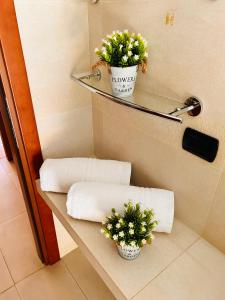 a bathroom with two towels and flowers on a shelf at Giada Apartment in Verona