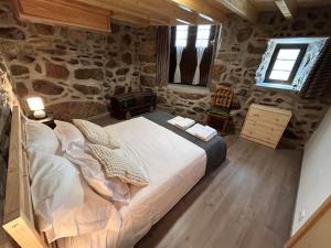 Un dormitorio con una cama grande y una pared de piedra. en Casas dos Senadores by Vale do Zêzere Hotel, en Manteigas