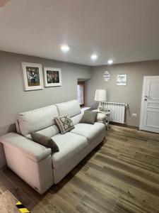 uma sala de estar com um sofá branco e uma mesa em Al Cottage em Oliveto Lario