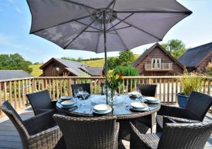 a table with an umbrella on a deck at Trenant 2 in Little Petherick