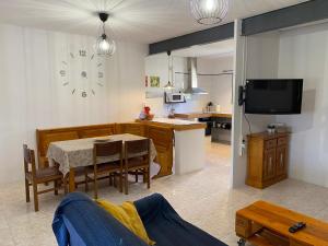 cocina y sala de estar con mesa y reloj en El Molí, en Ulldemolins