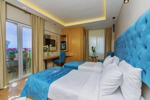 a hotel room with two beds with a blue headboard at History Hotel in Istanbul