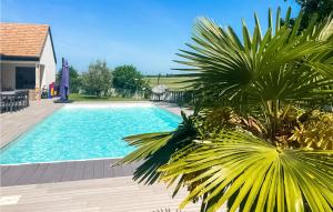 einen Pool mit einer Palme neben einem Haus in der Unterkunft Gorgeous Home In Pierre-leve With Kitchen 