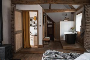 a bedroom with a bathroom with a tub and a sink at La Grenouillère in Montreuil-sur-Mer