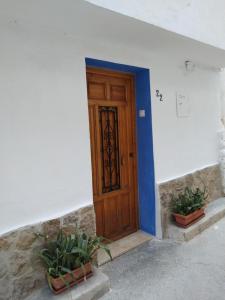 a wooden door in a white building with two potted plants at La Casica in Chulilla