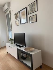 uma sala de estar com uma televisão num armário branco em Lilien apartman em Veternik