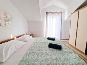a bedroom with a large bed with two pillows on it at Vila Cicovac in Novalja