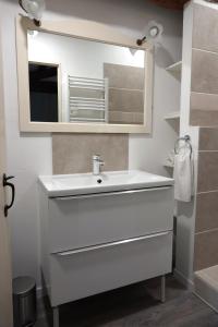 a bathroom with a white sink and a mirror at Gite Rural La Maison Mauve in Ventouse