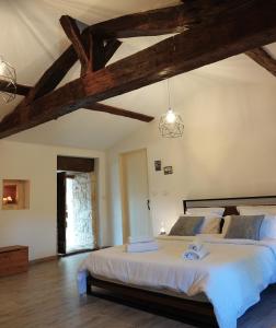Un dormitorio con una cama grande en una habitación con techos de madera. en Gite Rural La Maison Mauve, en Ventouse