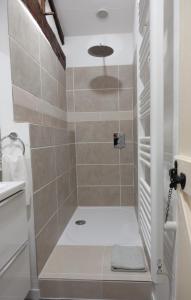 a bathroom with a shower with beige tiles at Gite Rural La Maison Mauve in Ventouse