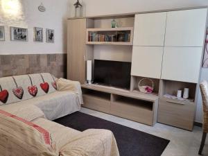 un salon avec un canapé et une télévision à écran plat dans l'établissement OLdBIA, à Olbia
