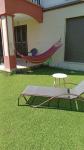 a hammock and a chair and a table in a yard at Relax Apartment Costa Esuri in Ayamonte