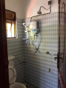 ein Bad mit einer Dusche und einem WC. in der Unterkunft BIMS Vacation Rental in Fort Portal