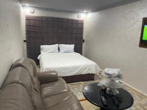 een woonkamer met een bed, een bank en een tafel bij Hébergement dakhla plaisance in Dakhla