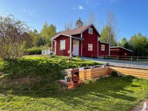 ein rotes Haus mit einem Zaun davor in der Unterkunft Loves Bondgård in Sparreholm