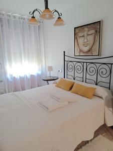 a bedroom with a bed with two towels on it at Relax Apartment Costa Esuri in Ayamonte